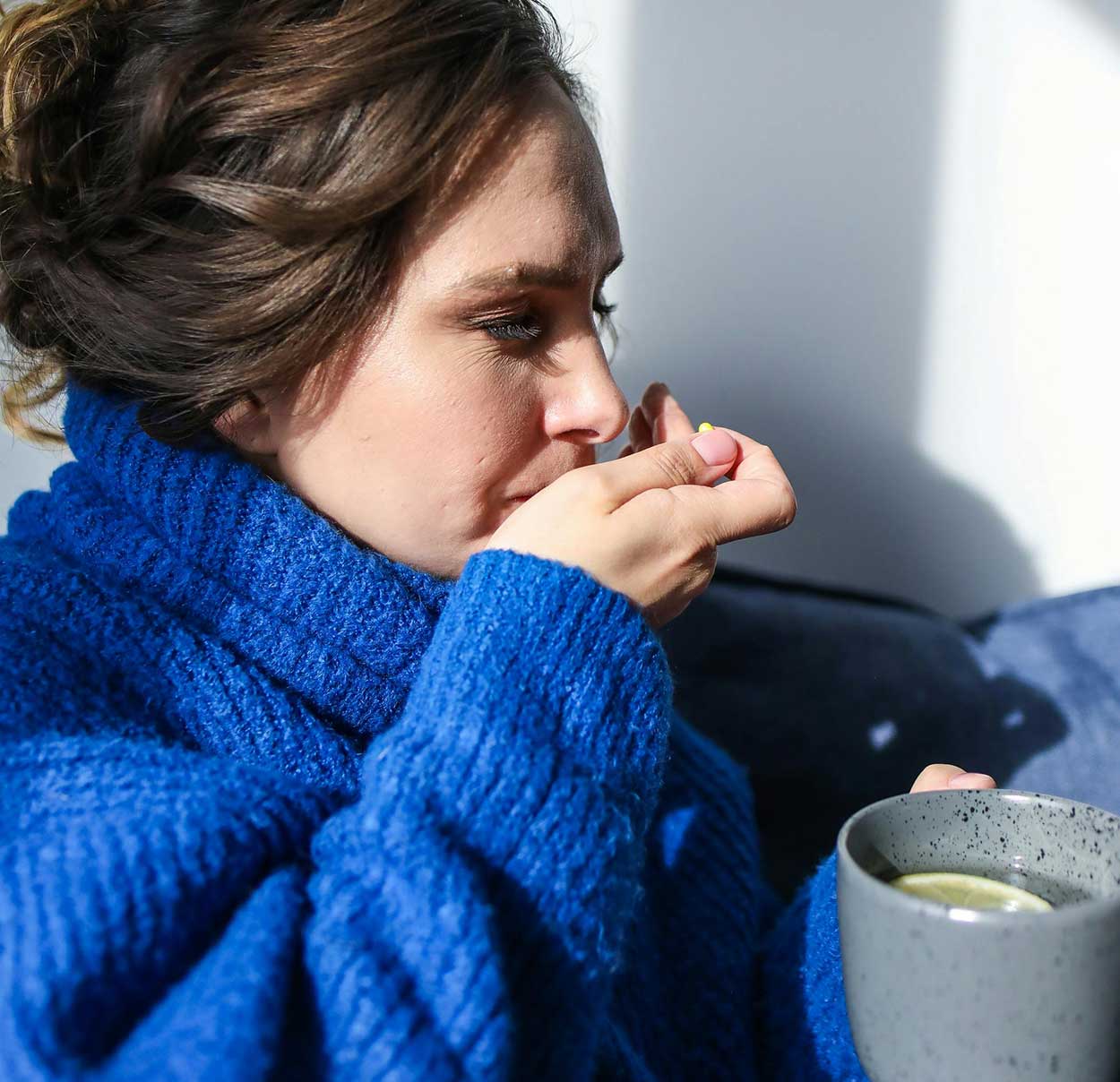 Woman with cold drinking tea