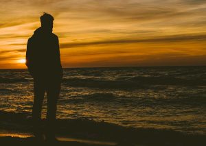 Person looking over the ocean at sunset